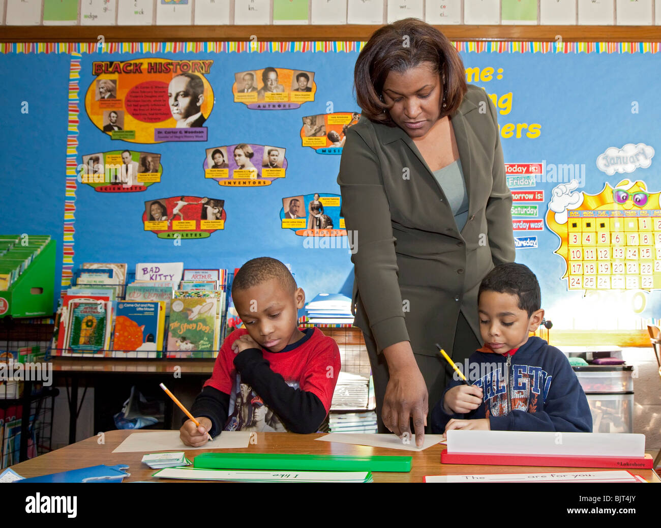 Detroit, Michigan - First grade teacher Ivy Bailey helps two students at MacDowell Elementary School. Stock Photo