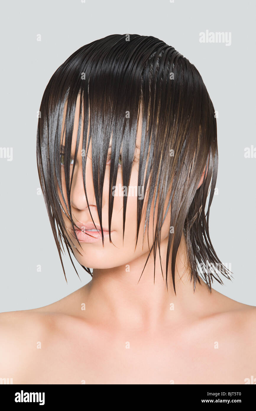 A woman with wet hair covering her face Stock Photo