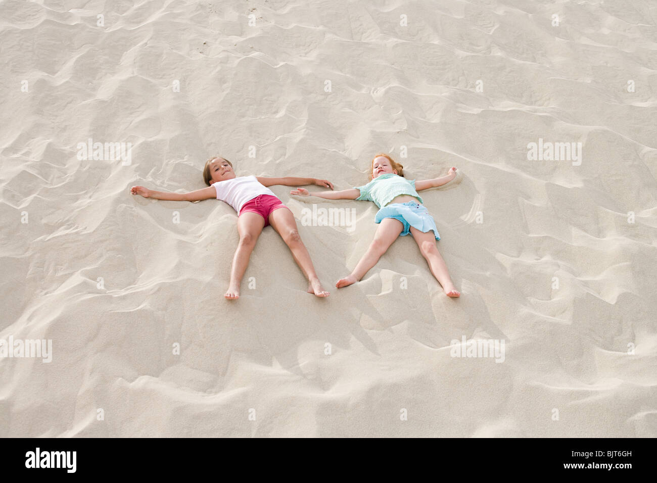 Two girls lying on a beach Stock Photo