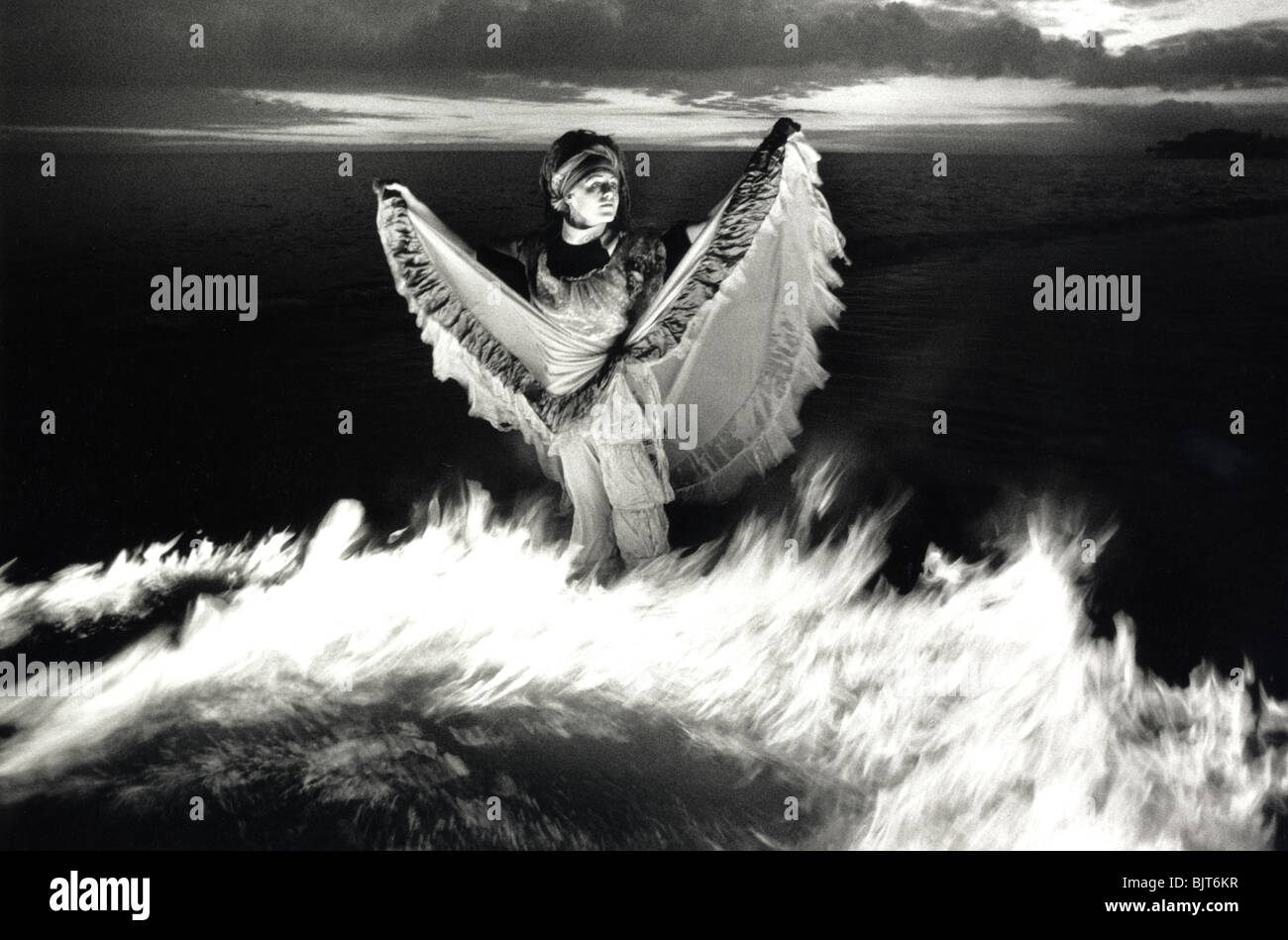 A Brighton Festival performer, playing with fire in the sea on Brighton Beach. Health and Safety officials restricted her act. Stock Photo