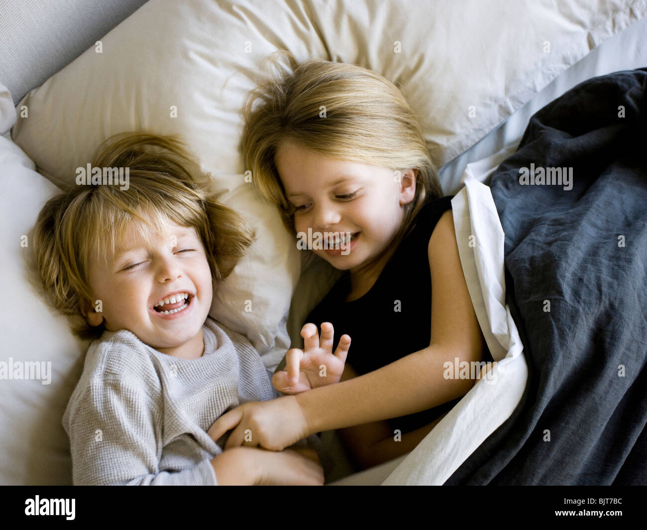 USA, Utah, Provo, Brother and sister (2-5) lying in bed Stock Photo