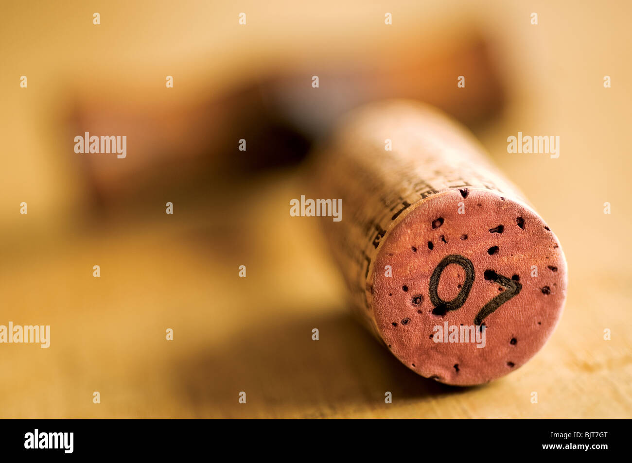 Close up of a Wine Bottle Cork Stopper and classic old wooden Corkscrew on top of table. Close-up concept number seven 7 printed on wine cork stopper. Stock Photo