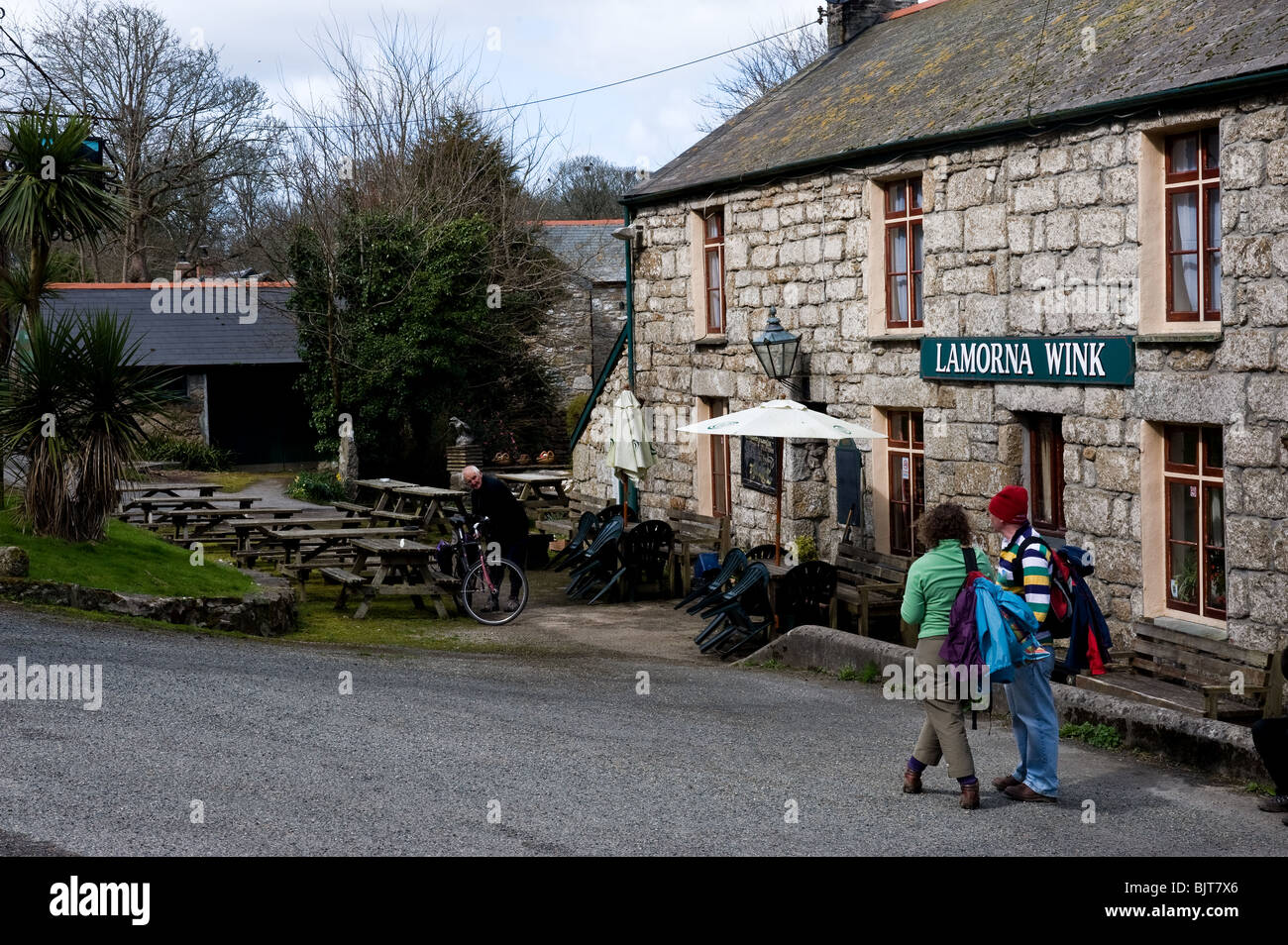 Holidaymakers visitors tourists waiting outside the Lamorna Wink public house in Cornwall. Stock Photo