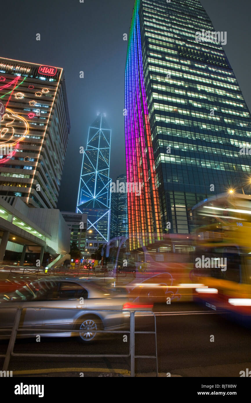 Office blocks lit up at night and cars in Hong Kong, China. This densely populated city has a massive carbon footprint. Stock Photo