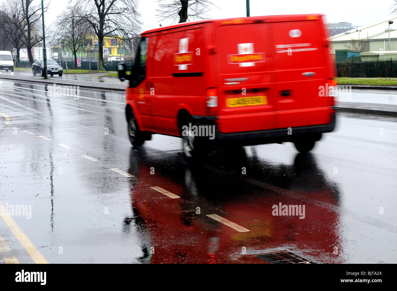 Post Office Van Driving  on wet Road Surface Stock Photo