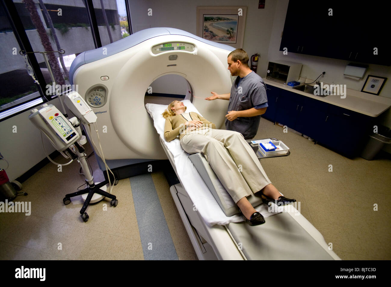 A medical technician prepares a patient for a CT examination at a California radiology clinic using a multi-slice CT scanner. Stock Photo