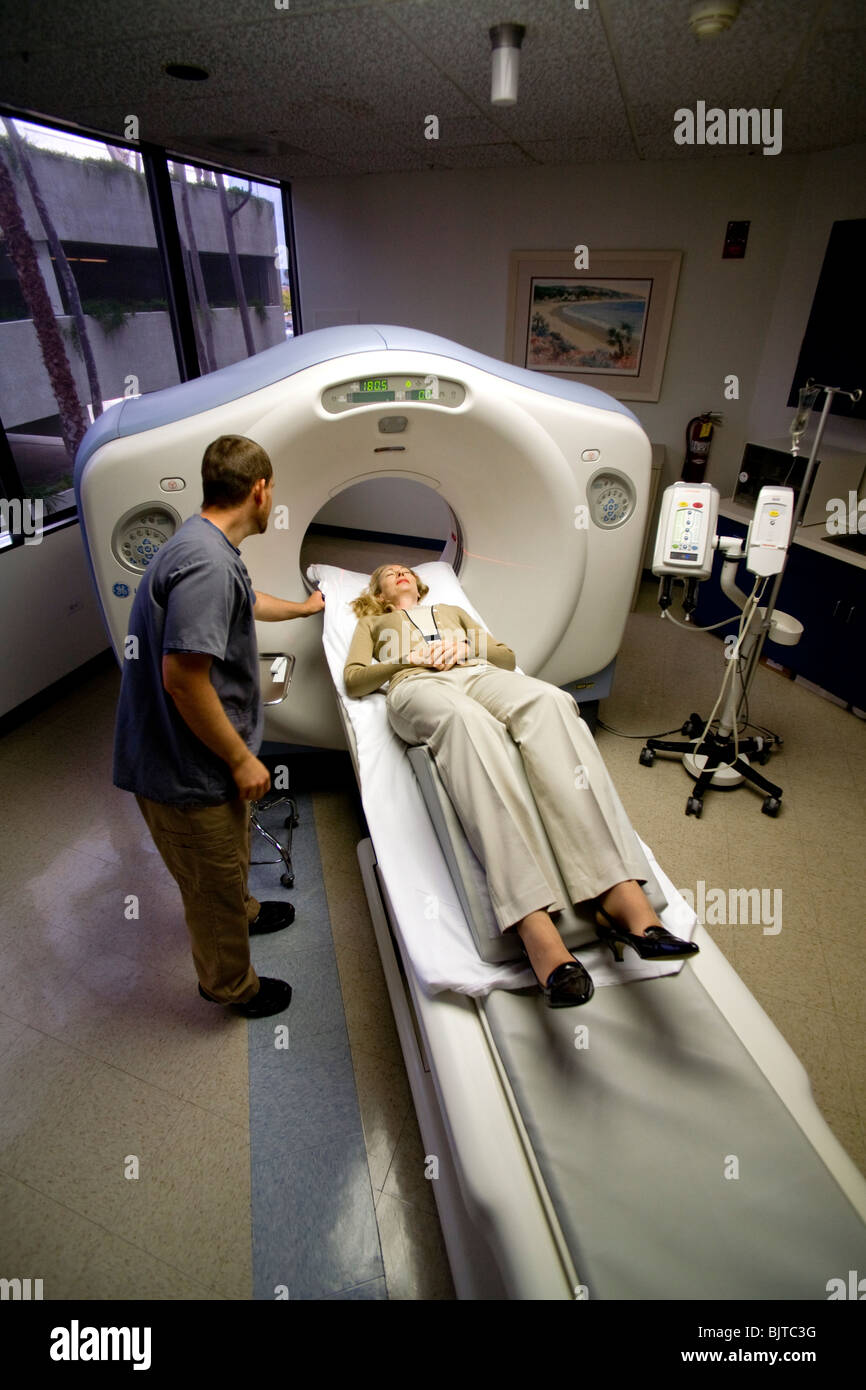 A medical technician prepares a patient for a CT examination at a