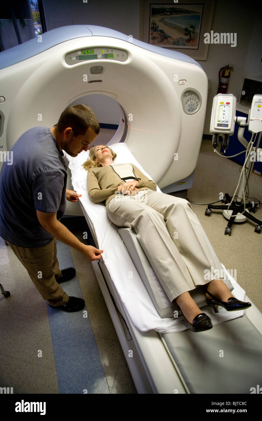 A medical technician prepares a patient for a CT examination at a California radiology clinic using a multi-slice CT scanner. Stock Photo
