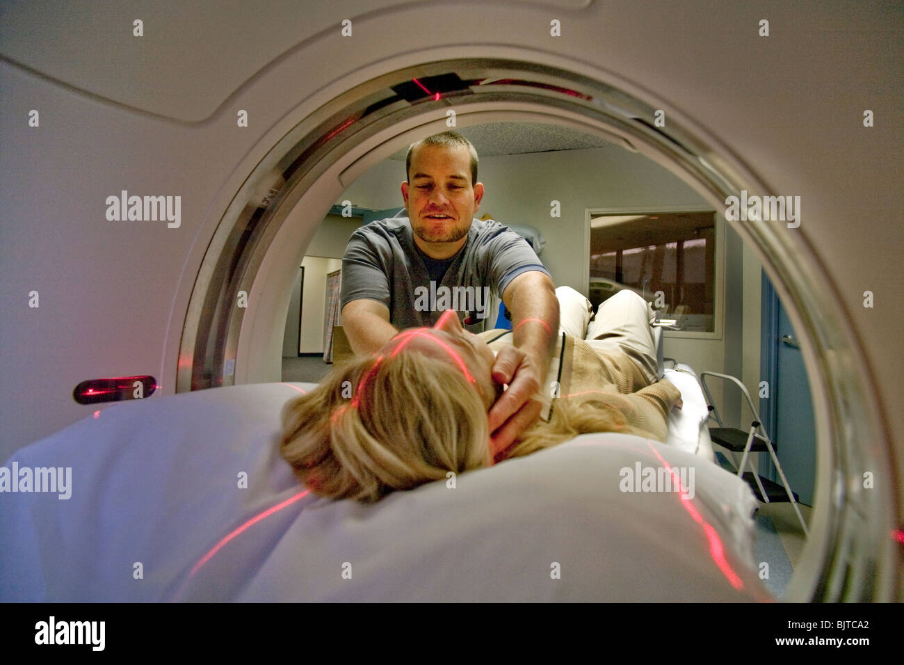 A medical technician prepares a patient for a CT examination at a California radiology clinic using a multi-slice CT scanner. Stock Photo