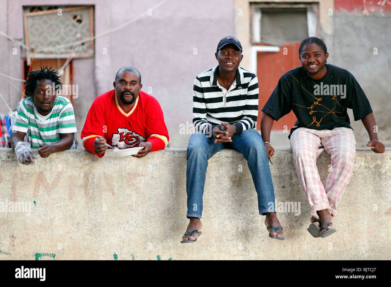 Four friends pose for photos on a house wall in Benguela, Angola. Africa. © Zute Lightfoot Stock Photo