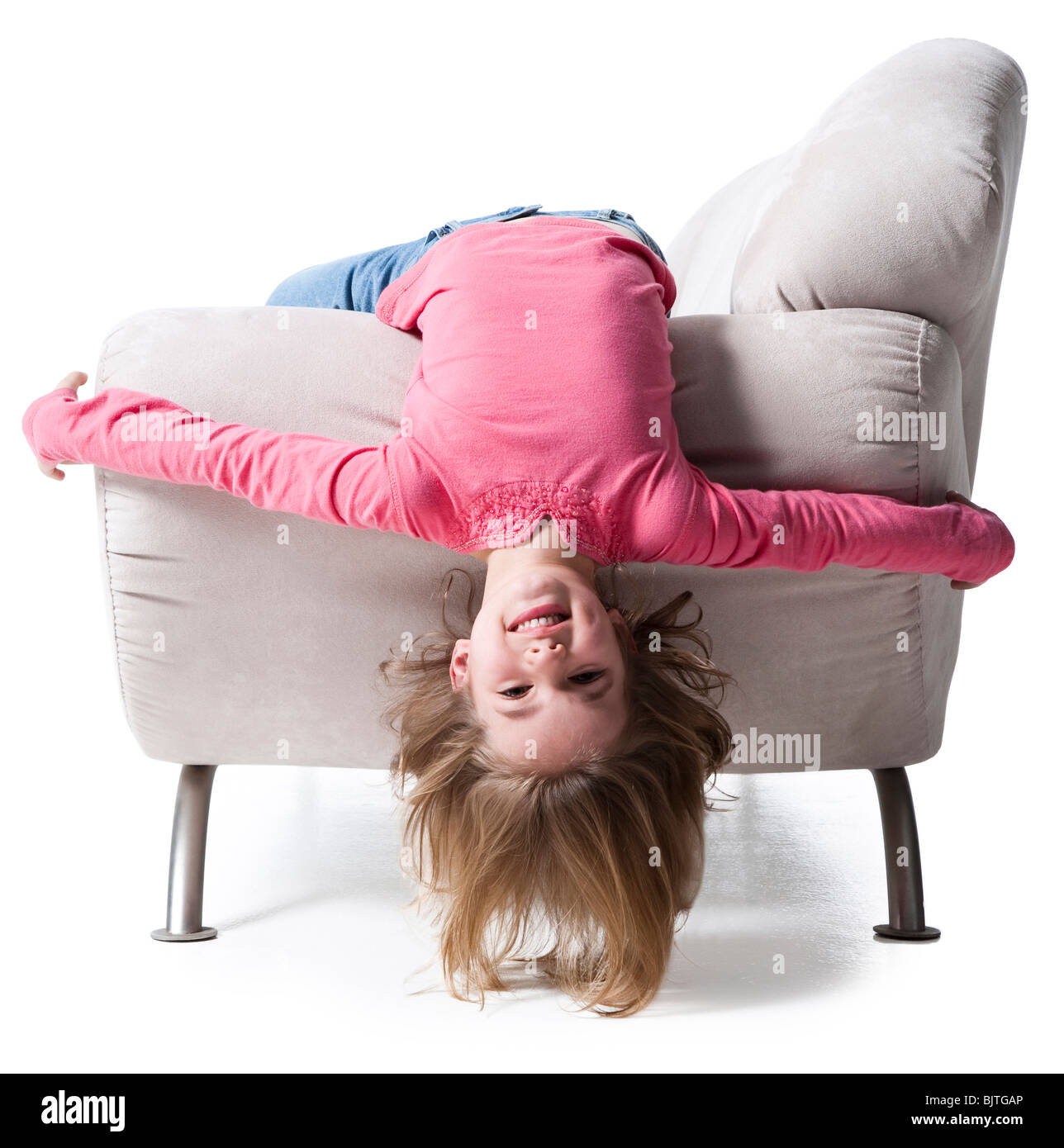Girl bending backwards over couch Stock Photo