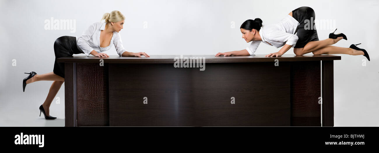 Two young woman on the large office table stock photo alamy
