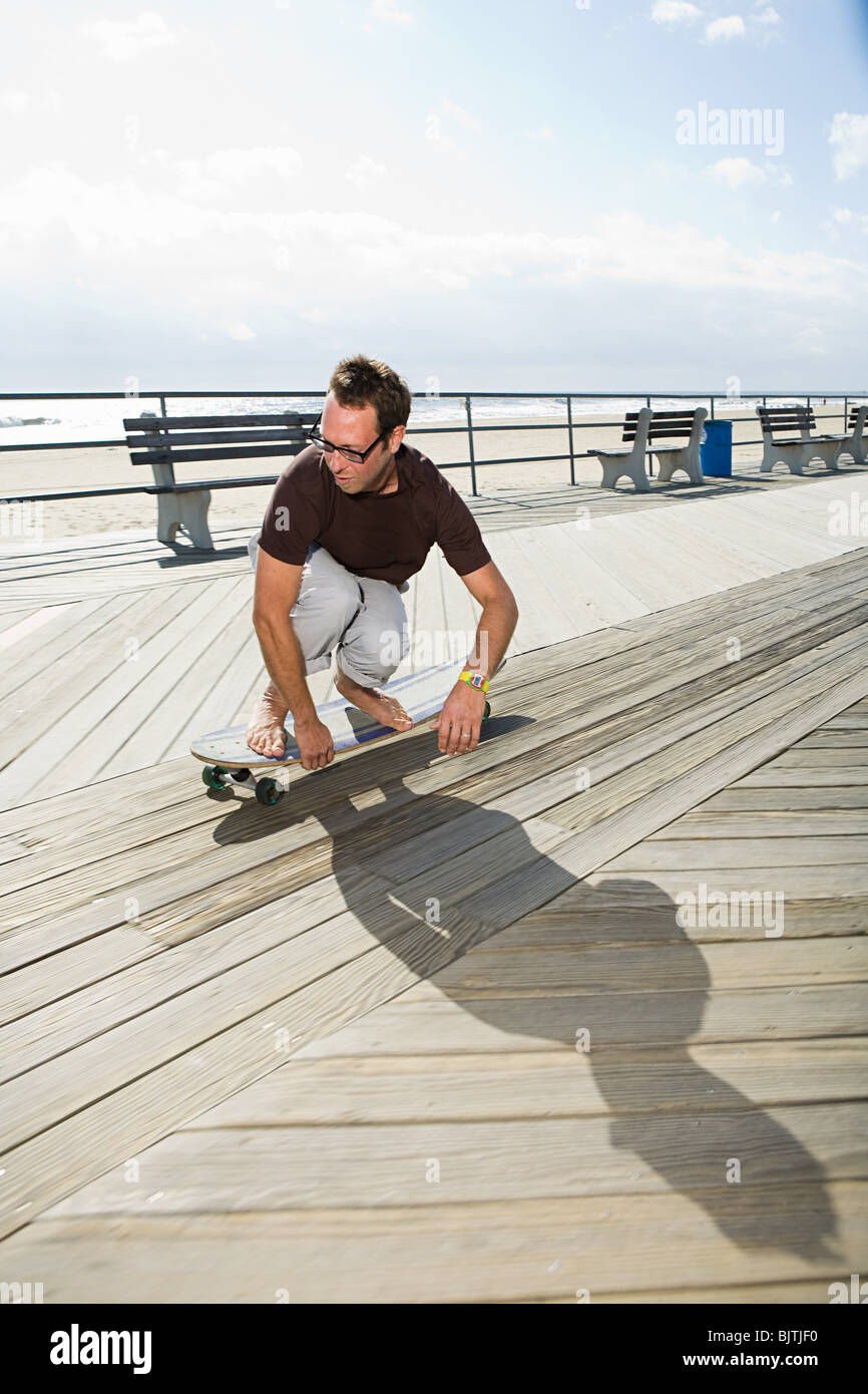 Man skateboarding on boardwalk Stock Photo Alamy