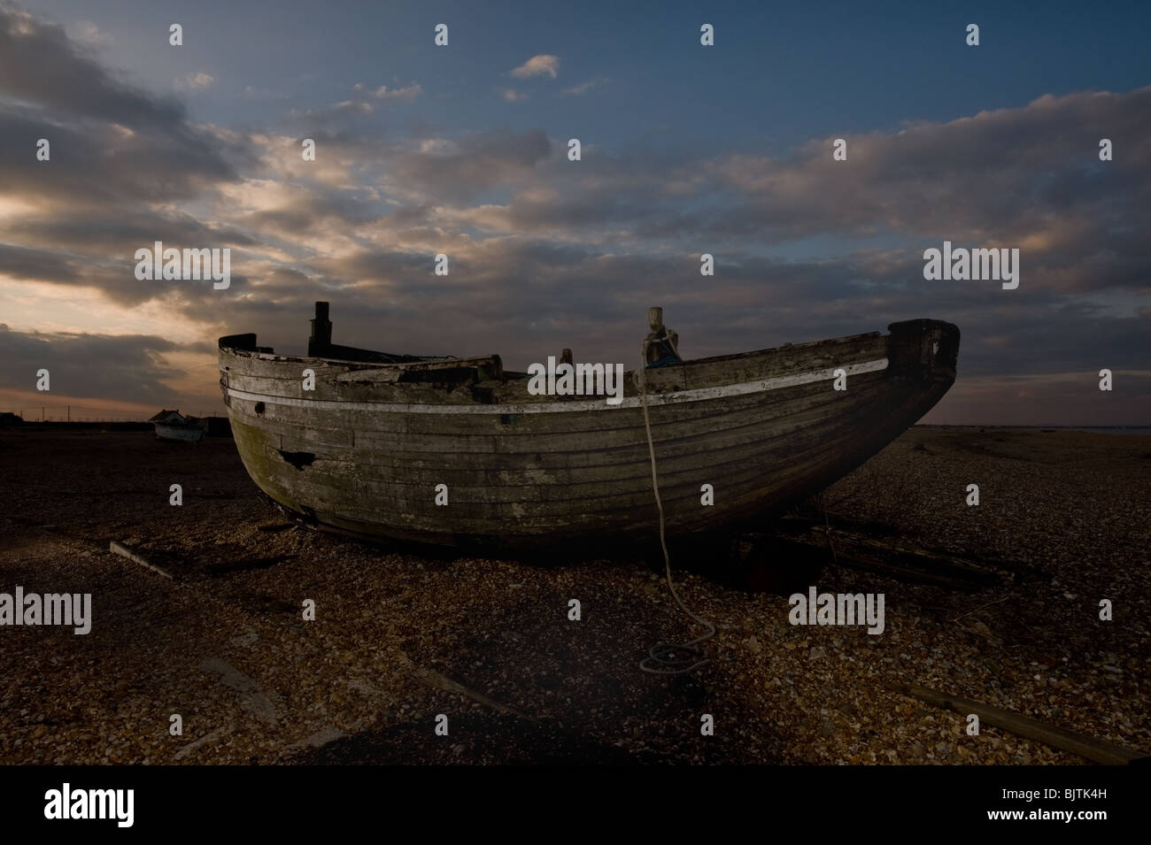 An abandoned fishing boat sits in the sunset on the Dungeness shingle ...