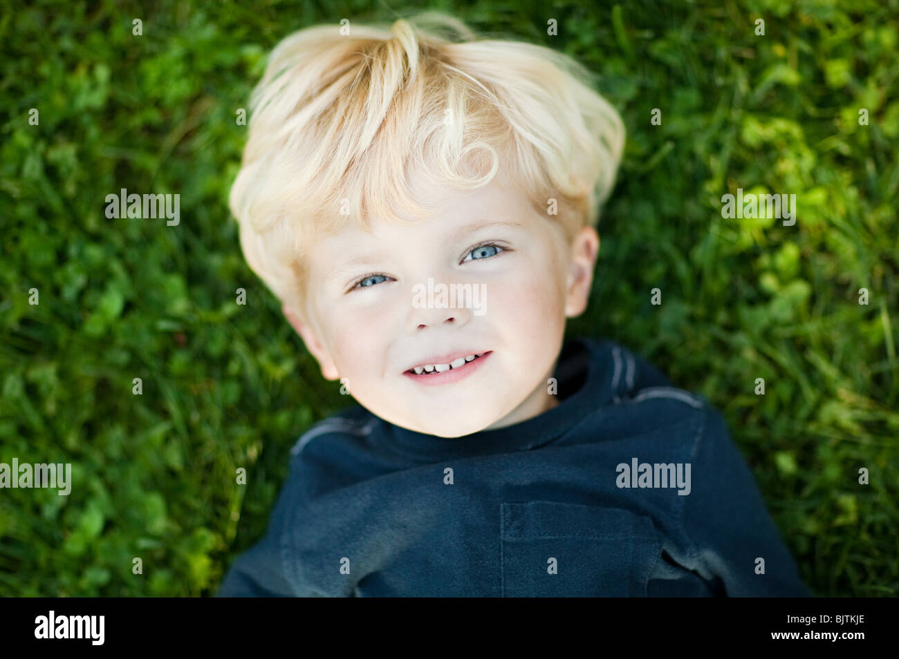 Boy lying on grass Stock Photo Alamy