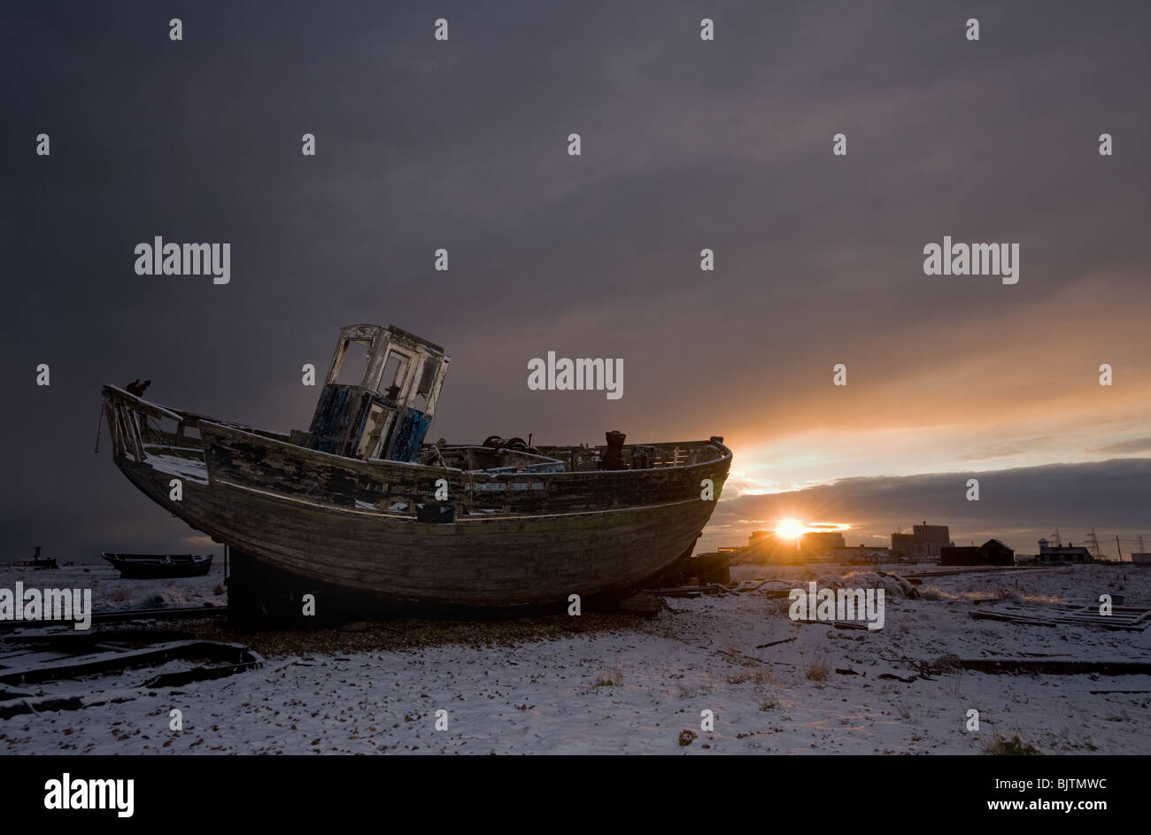 An abandoned fishing boat heads into the sunset at Dungeness, Kent. Stock Photo