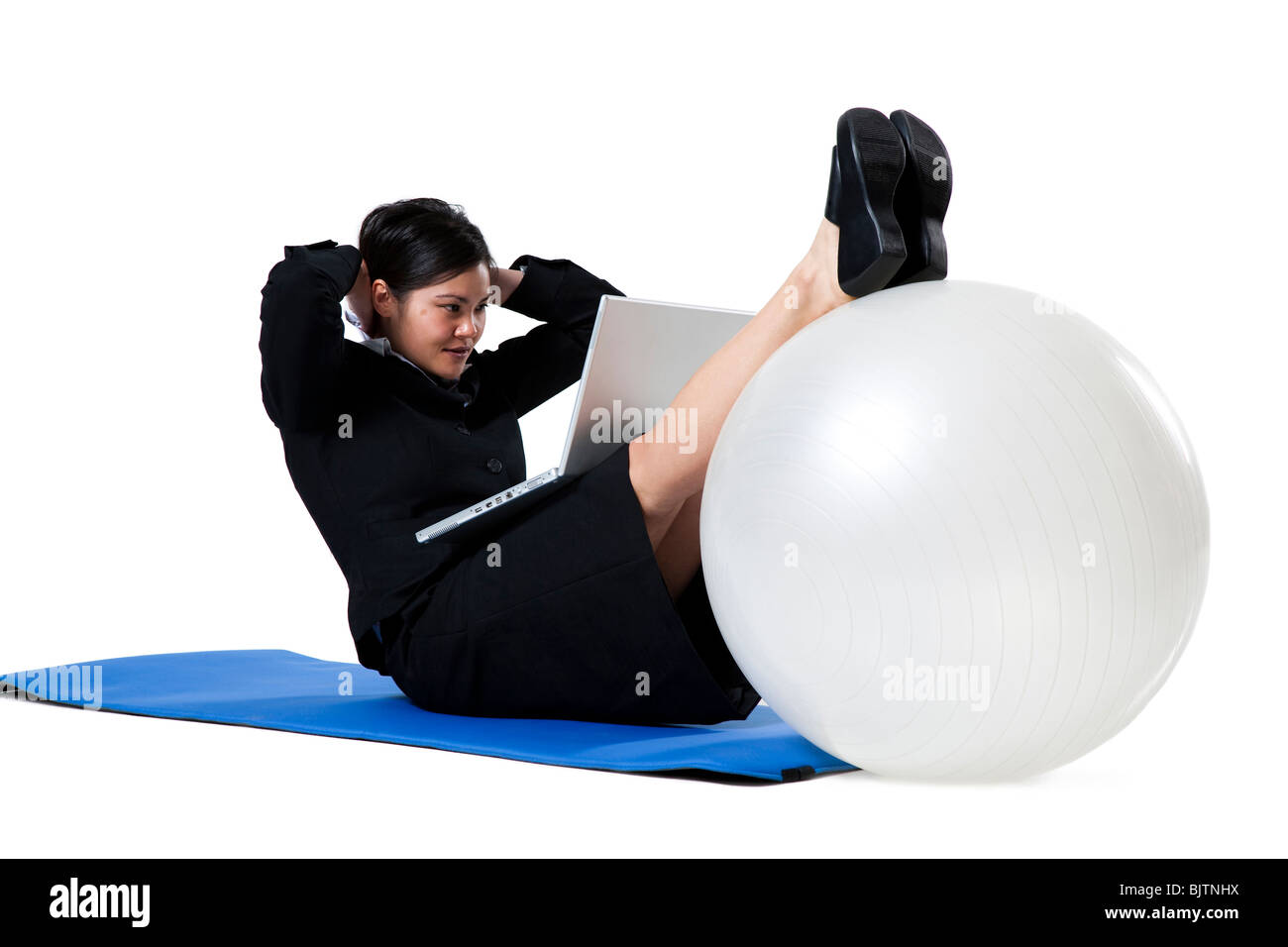 Woman doing yoga with laptop Stock Photo