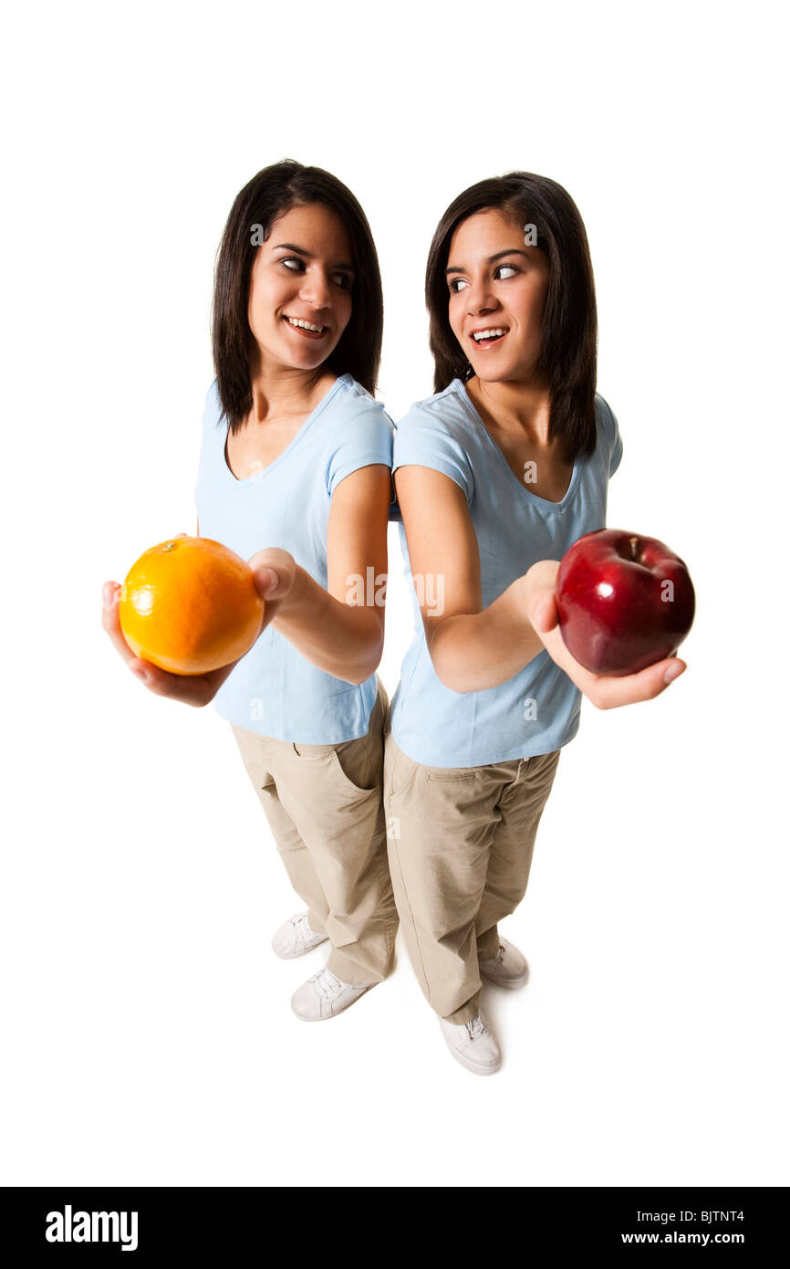 Sisters offering apple and orange Stock Photo