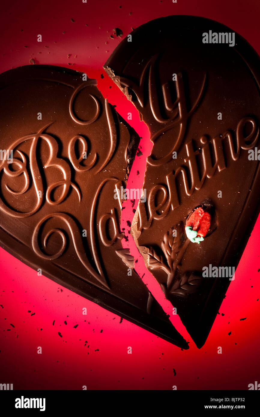 Chocolate valentine heart broken in two Stock Photo - Alamy