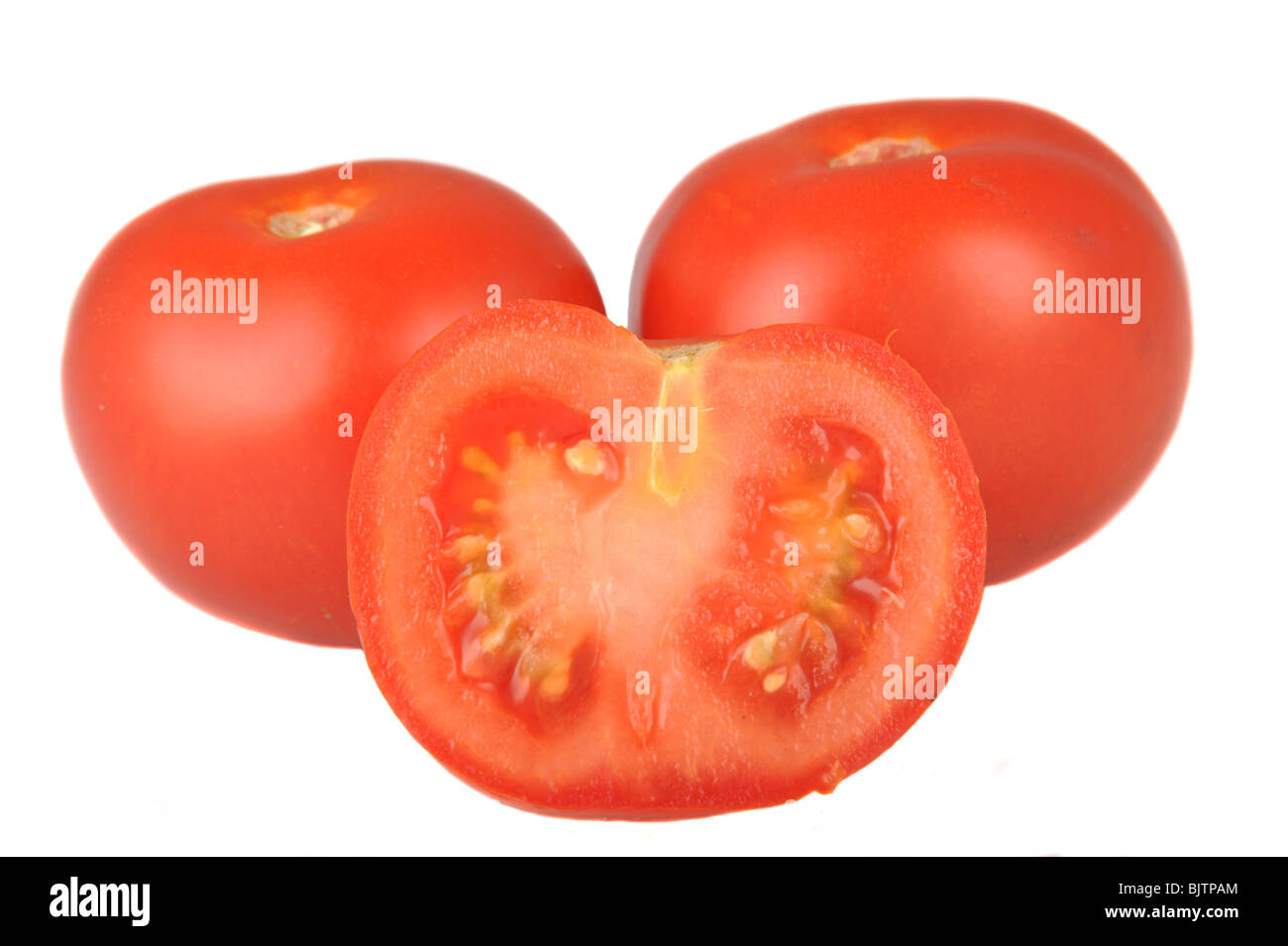 Tomatoes and half a tomato photographed in studio against a white background Stock Photo