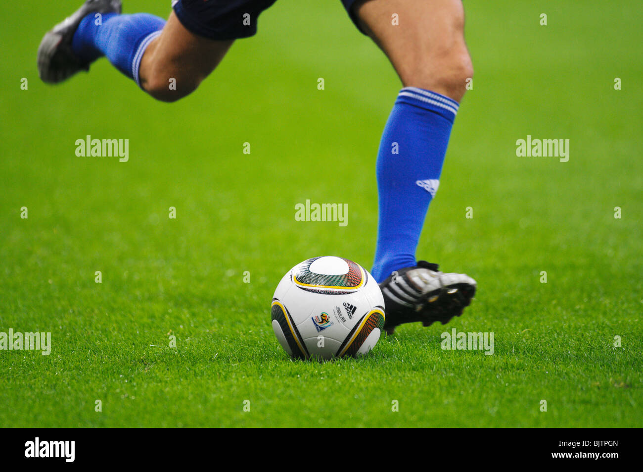 footballers legs and Jabulani, official matchball of the FIFA world Cup 2010 in South Africa Stock Photo