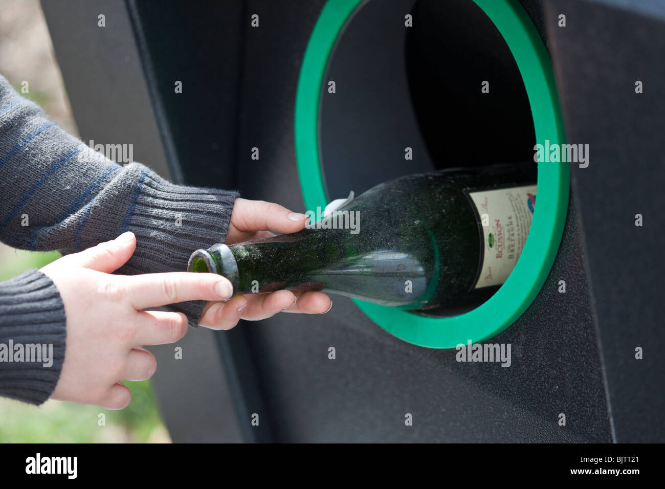A 9 year old boy puts bottles in to a recycling bin, Switzerland. Charles Lupica Stock Photo