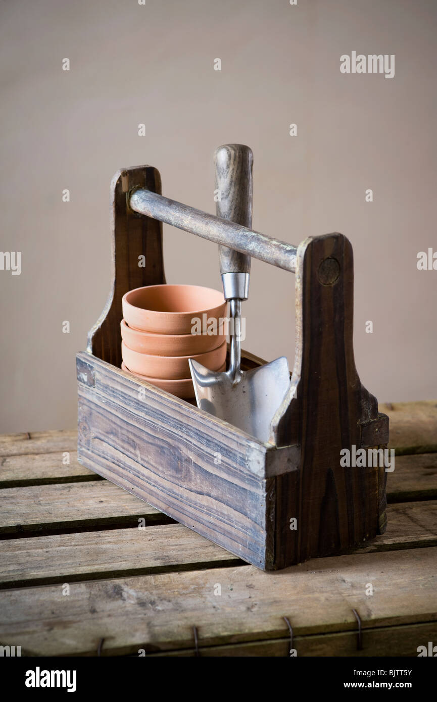 vintage wooden garden trug containing terracotta plant pots and a stainless steel trowel Stock Photo