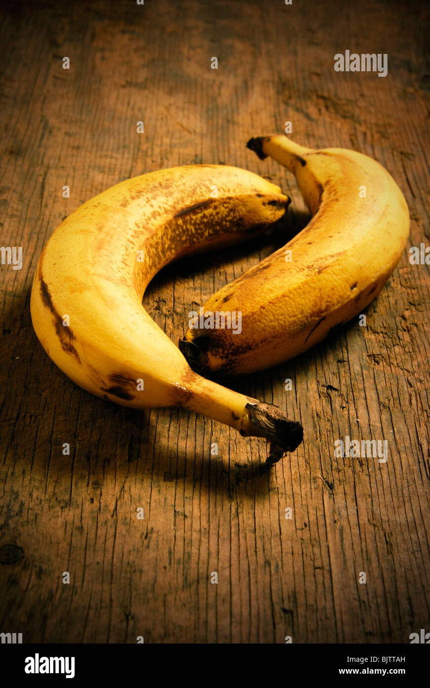 two bananas lying on an old wood table Stock Photo
