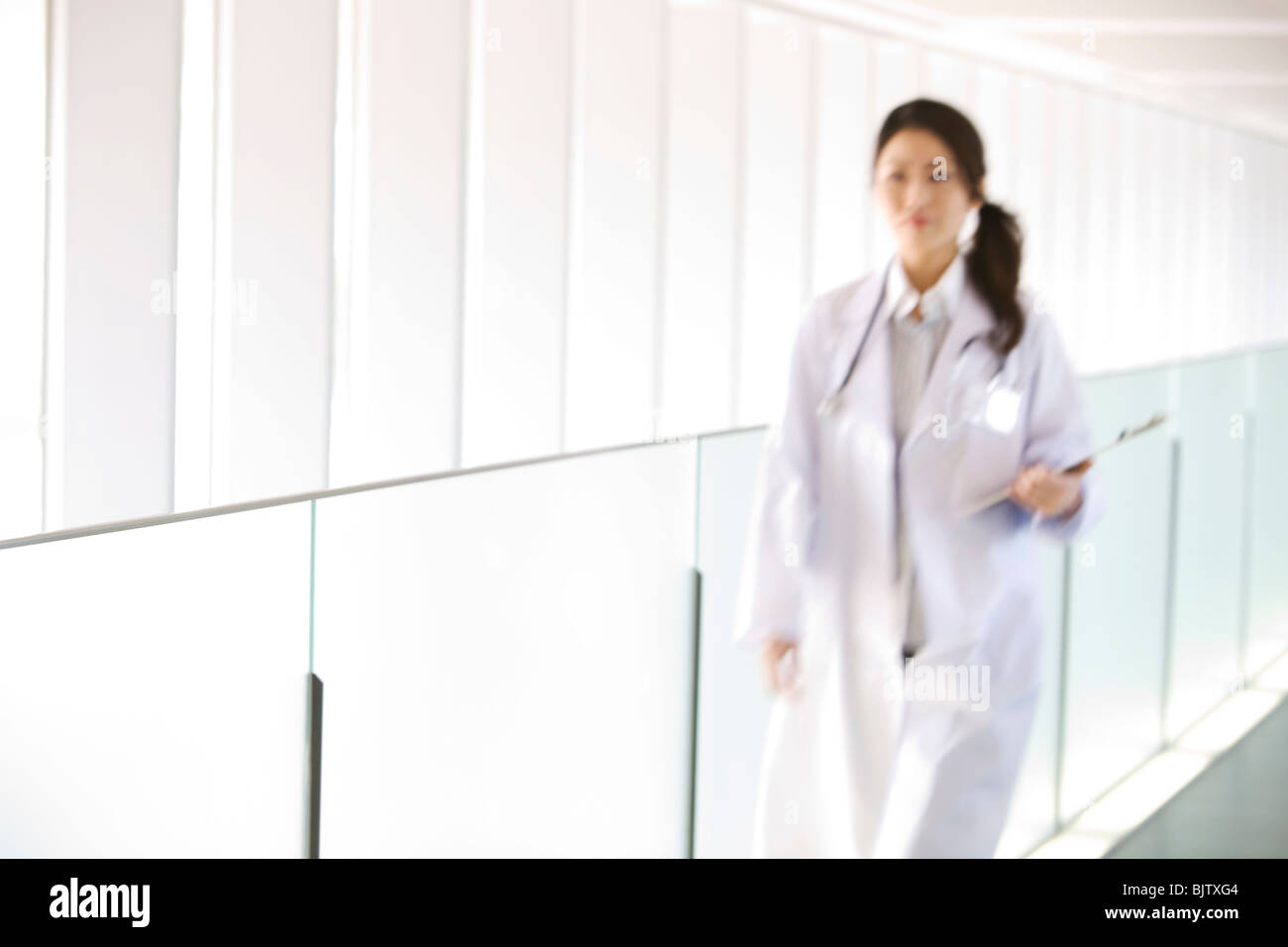 Doctor walking with chart through hallway Stock Photo - Alamy