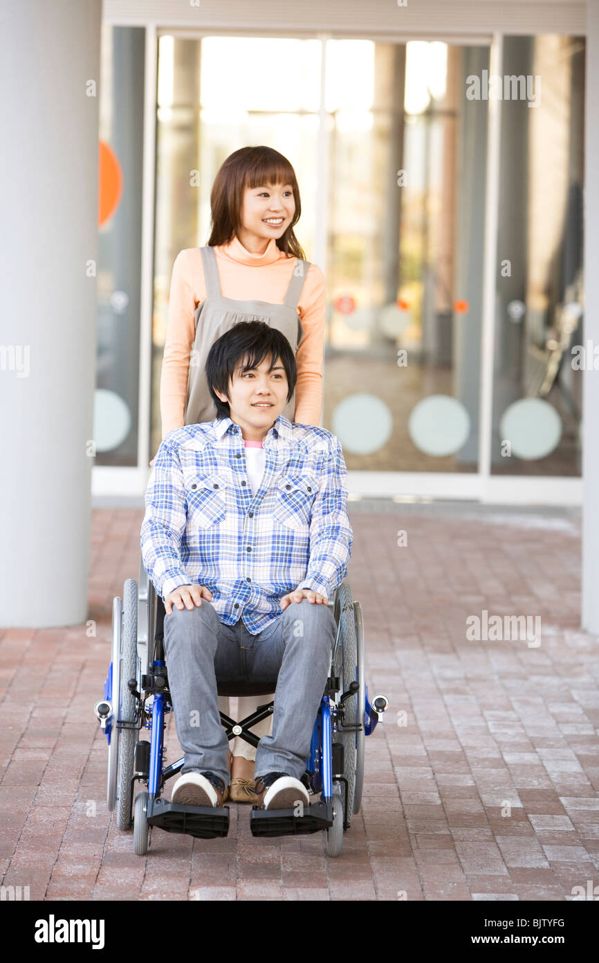 Woman pushing her boyfriend in a wheelchair Stock Photo - Alamy