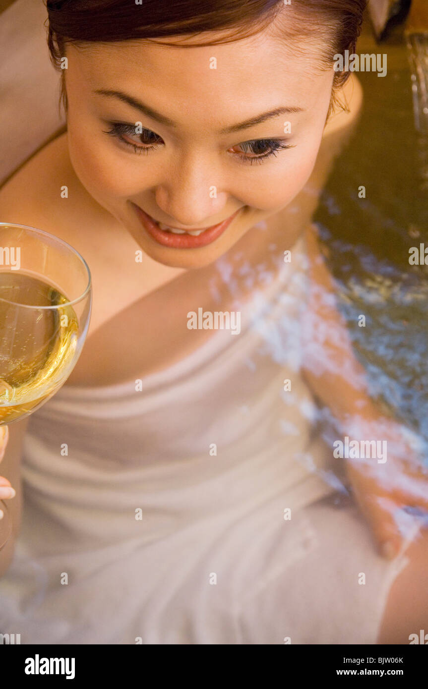 Woman enjoying a glass of wine in a hot tub Stock Photo Alamy