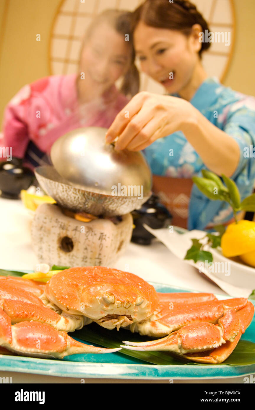 Women dressed in yukatas sitting down to eat a meal