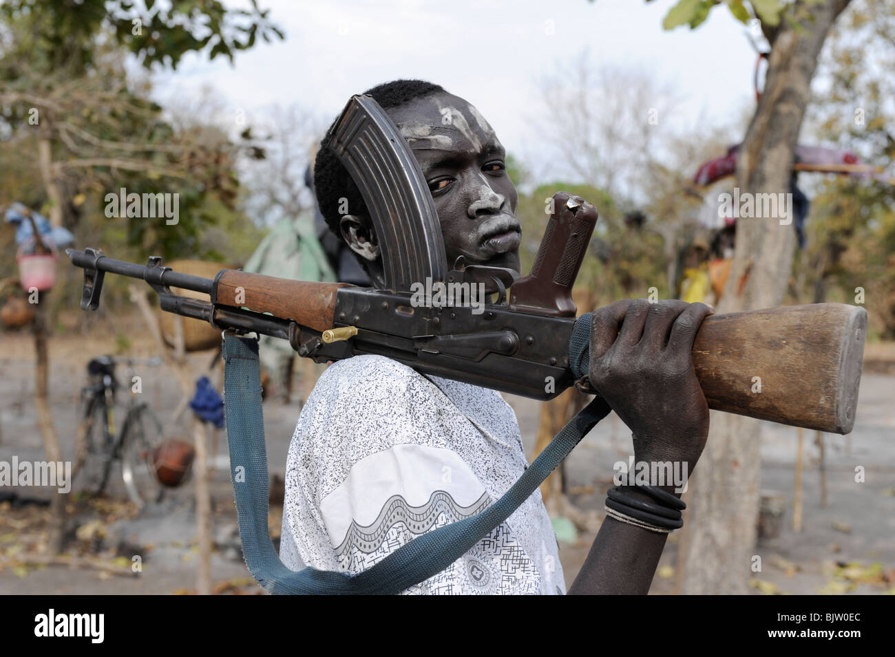 SOUTH-SUDAN, Cuibet near Rumbek, shepherd with ash smeared face posing with Kalashnikov machine gun AK-47 in cattle camp Stock Photo