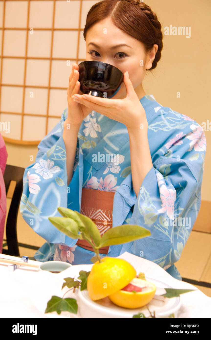 Woman dressed in a yukata and drinking miso soup Stock Photo Alamy