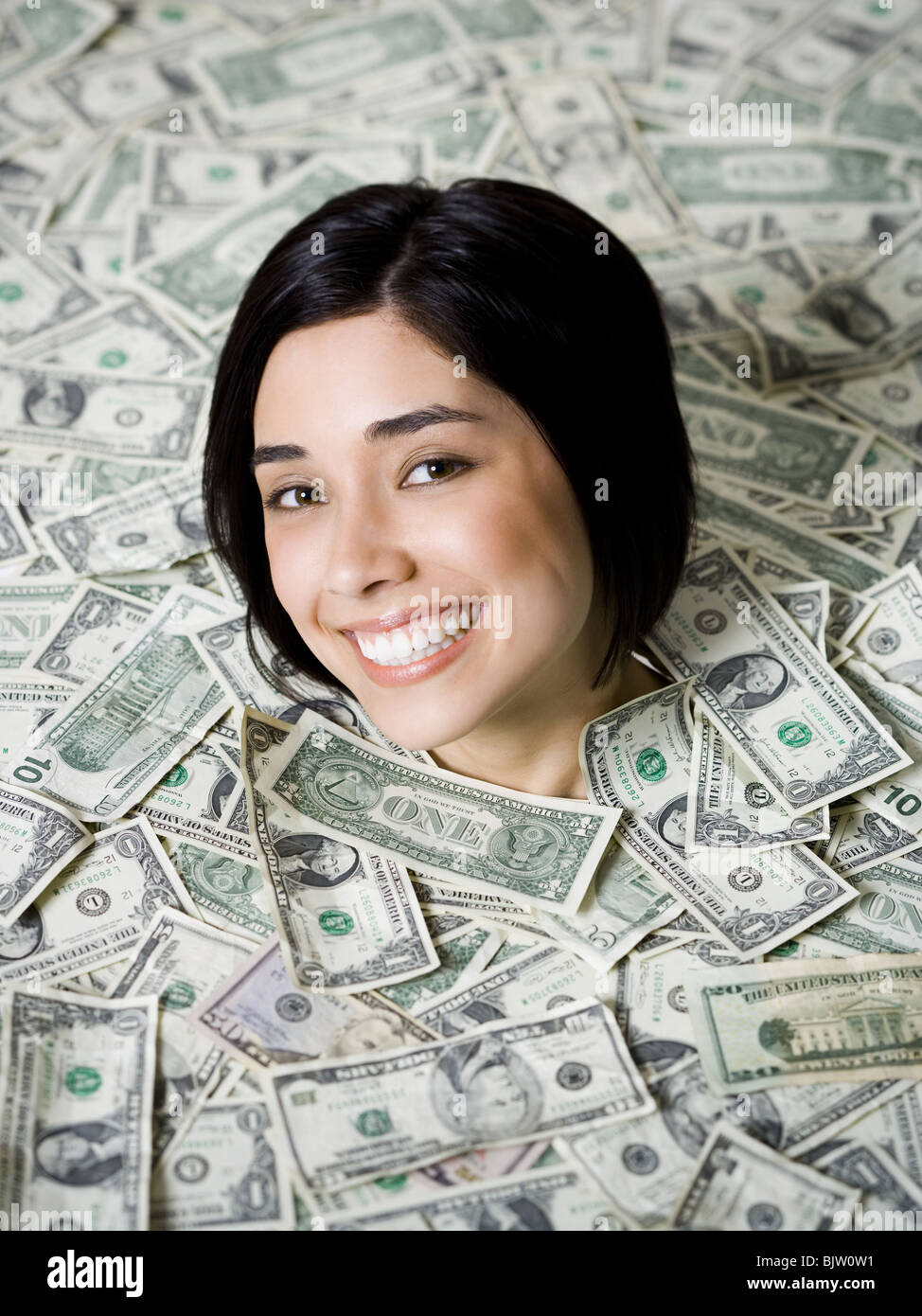 Head of woman emerging from dollar bills Stock Photo