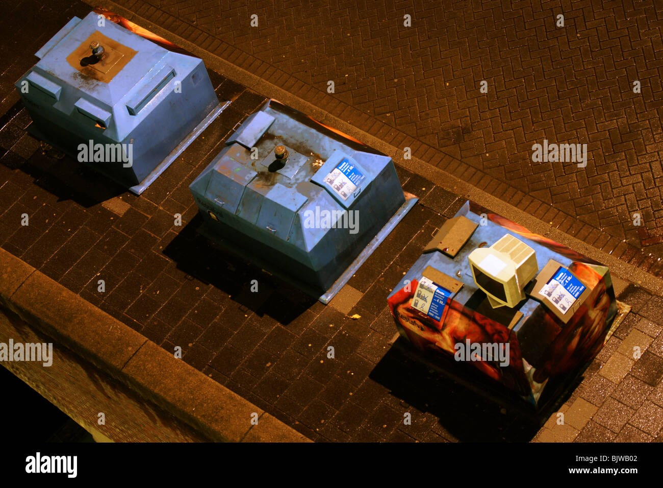 Three dustbins and computer screen at night at street of Rotterdam ...