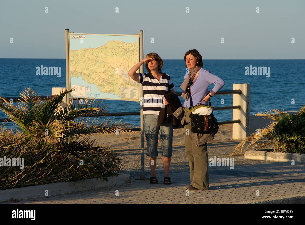 Two women tourists standing next to a map of Rethymnon county Crete Greece Stock Photo