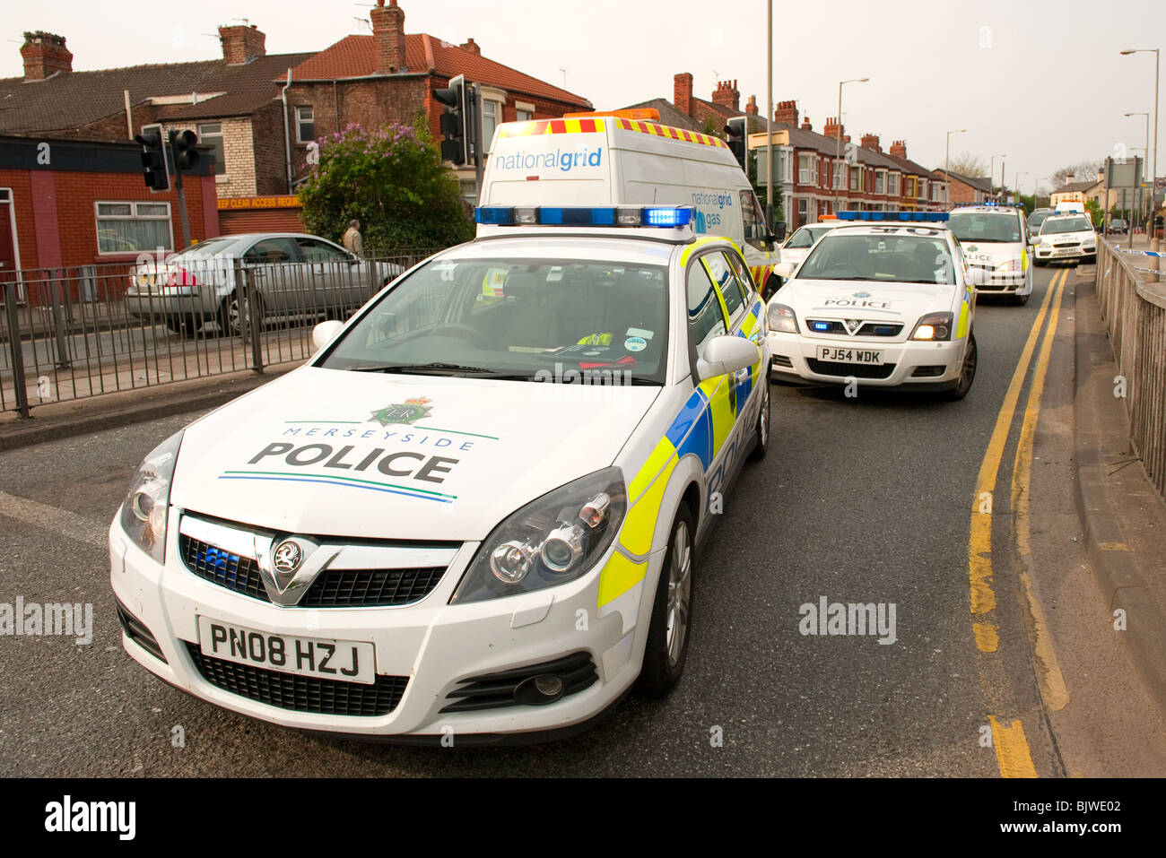 Several police cars and vehicles blocking road Stock Photo