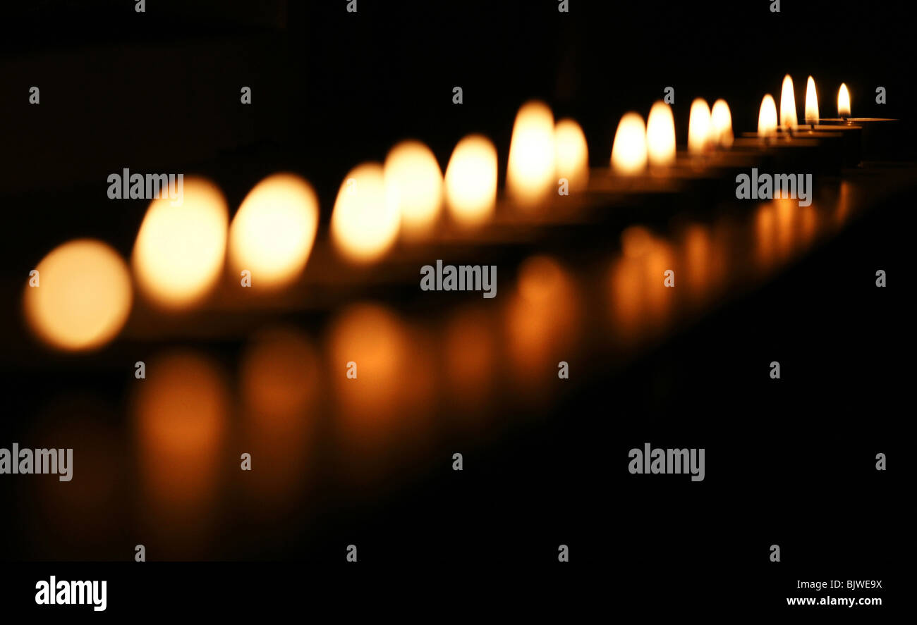 Many tealights candles lit at night flame detail Stock Photo Alamy