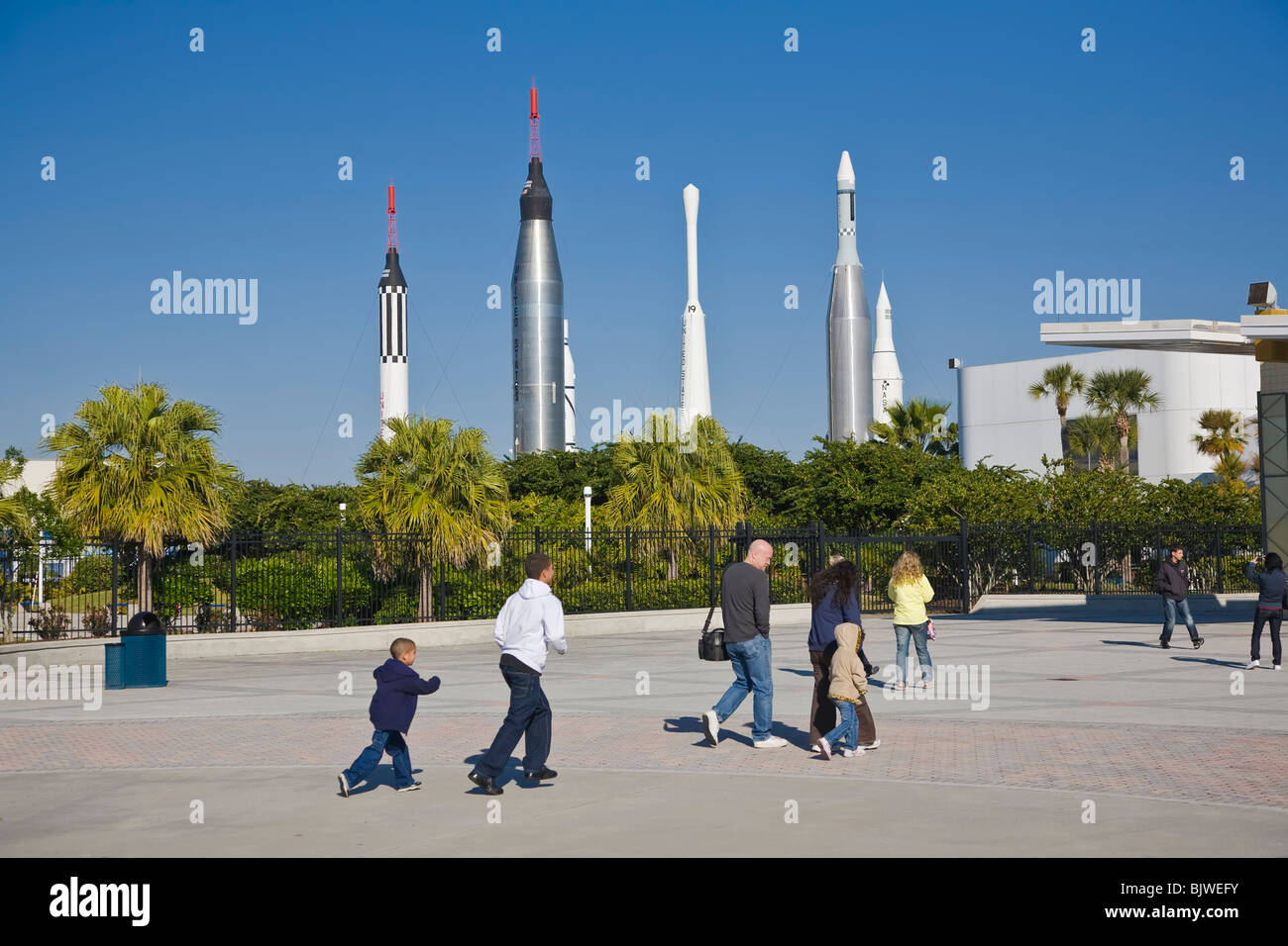 Family entering Kennedy Space Center Visitor Complex in Florida with the Rocket Garden in the background Stock Photo
