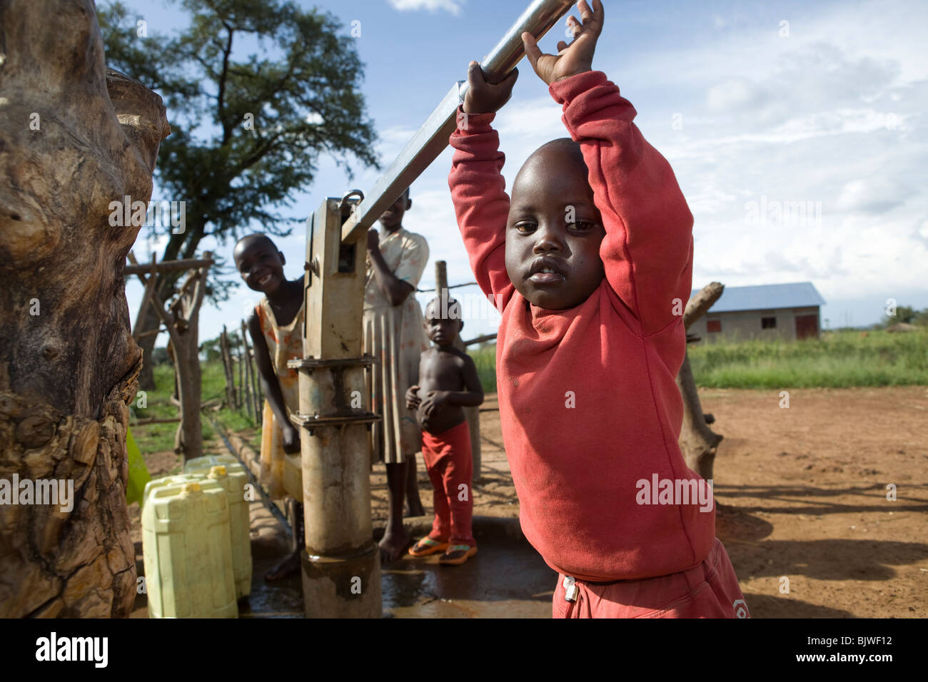 Children fetch fresh drinking water at a borehole in Amuria District, Teso Region, Uganda. Stock Photo
