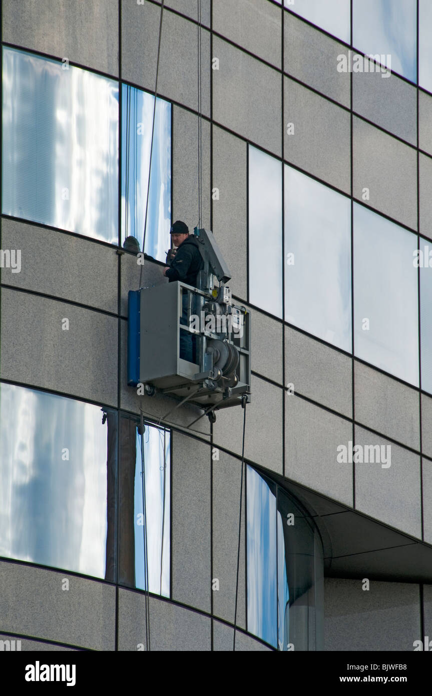A worker on an access platform on an office building in Barbirolli Square, Manchester, England, UK Stock Photo