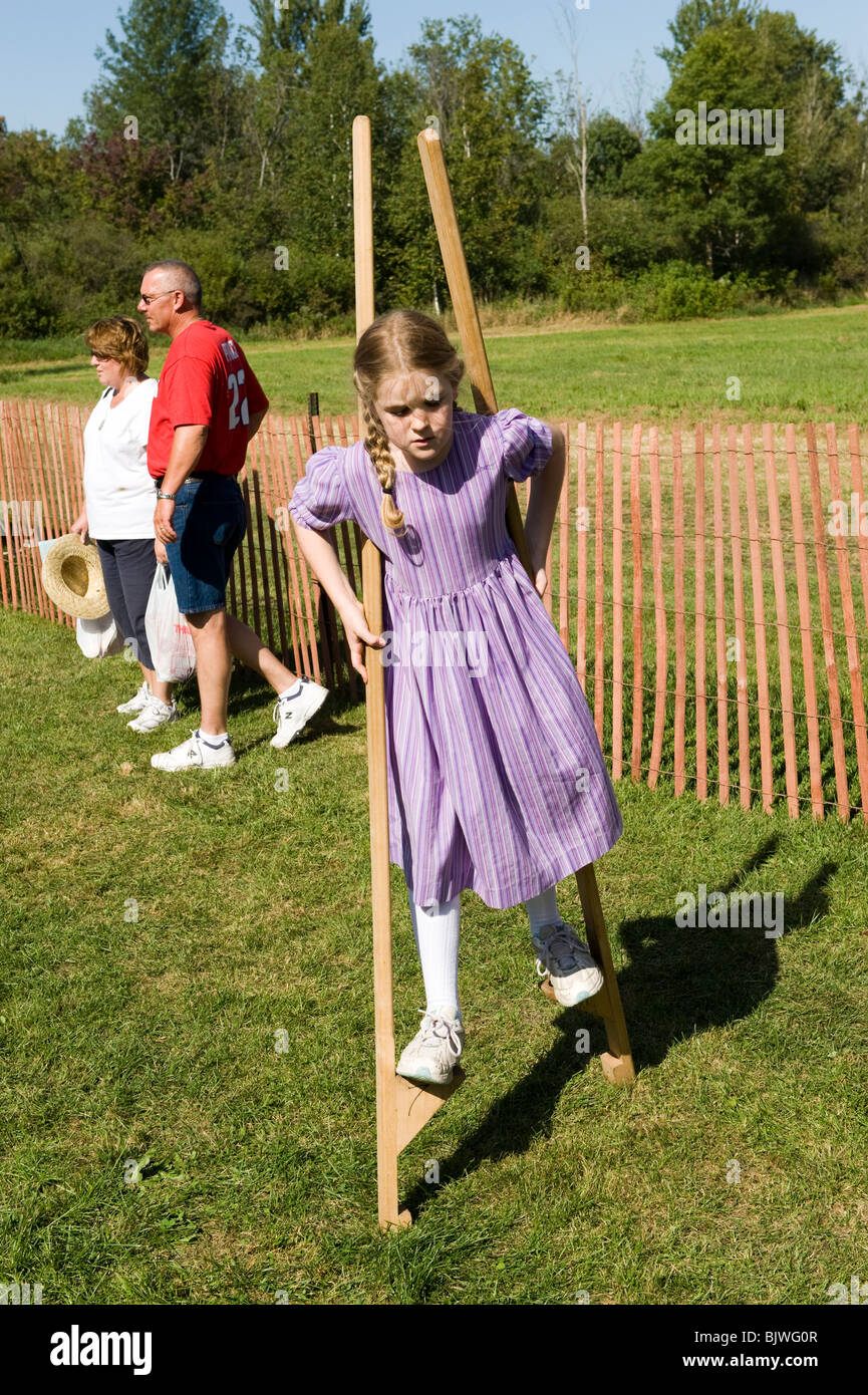 Child walking on wooden stilts learning how to balance on an object Stock Photo Alamy