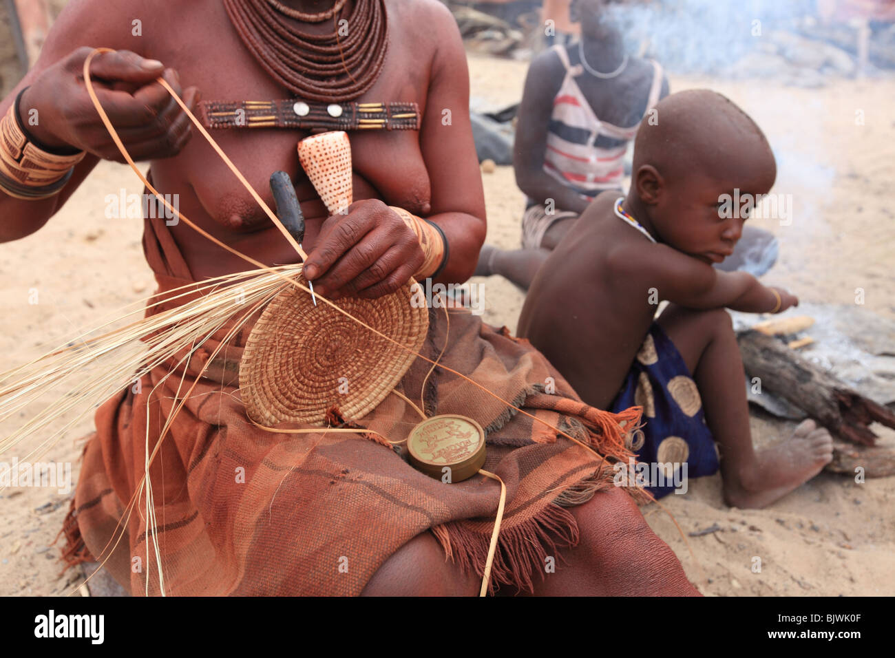 Himba woman weaves a traditional basket Stock Photo