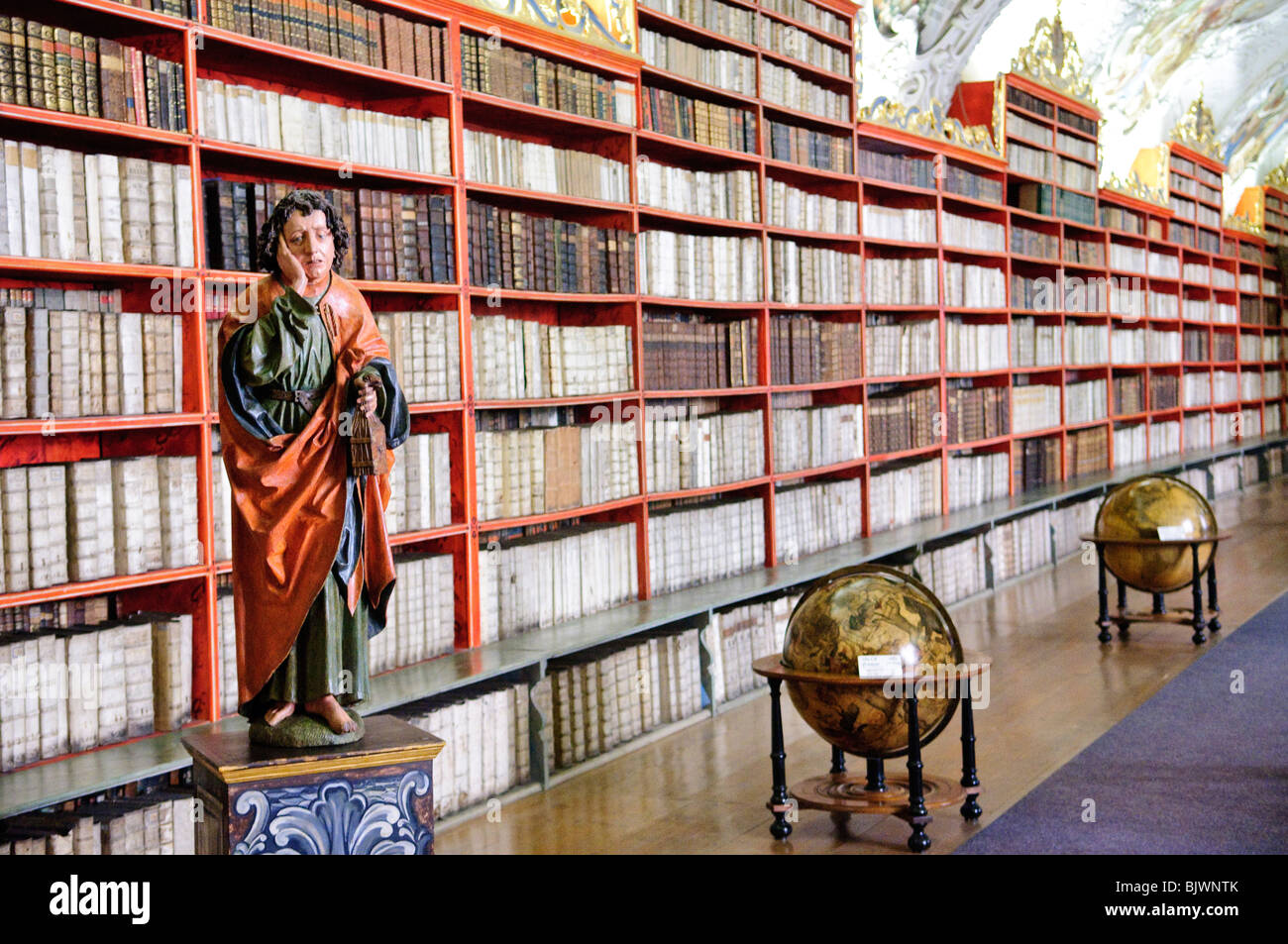 PRAGUE, Czech Republic - Strahov Library. Statue at left is of St. John the Evangelist. Book holder at right was specially designed for this library and keeps the books facing the reader as the wheel is turned. Stock Photo