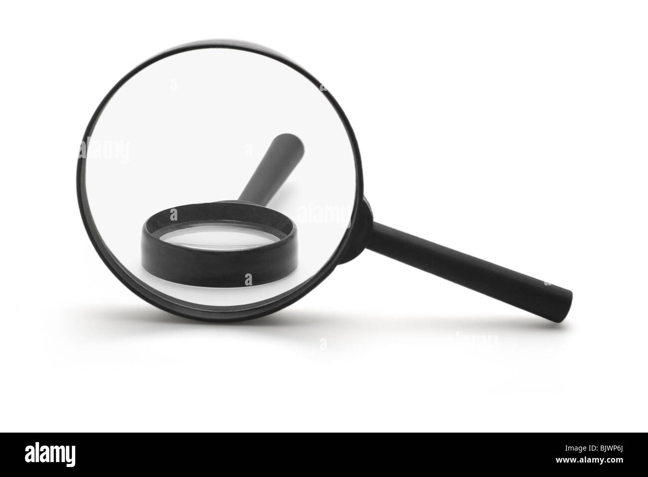 Magnifying glass over a smaller one on white background Stock Photo