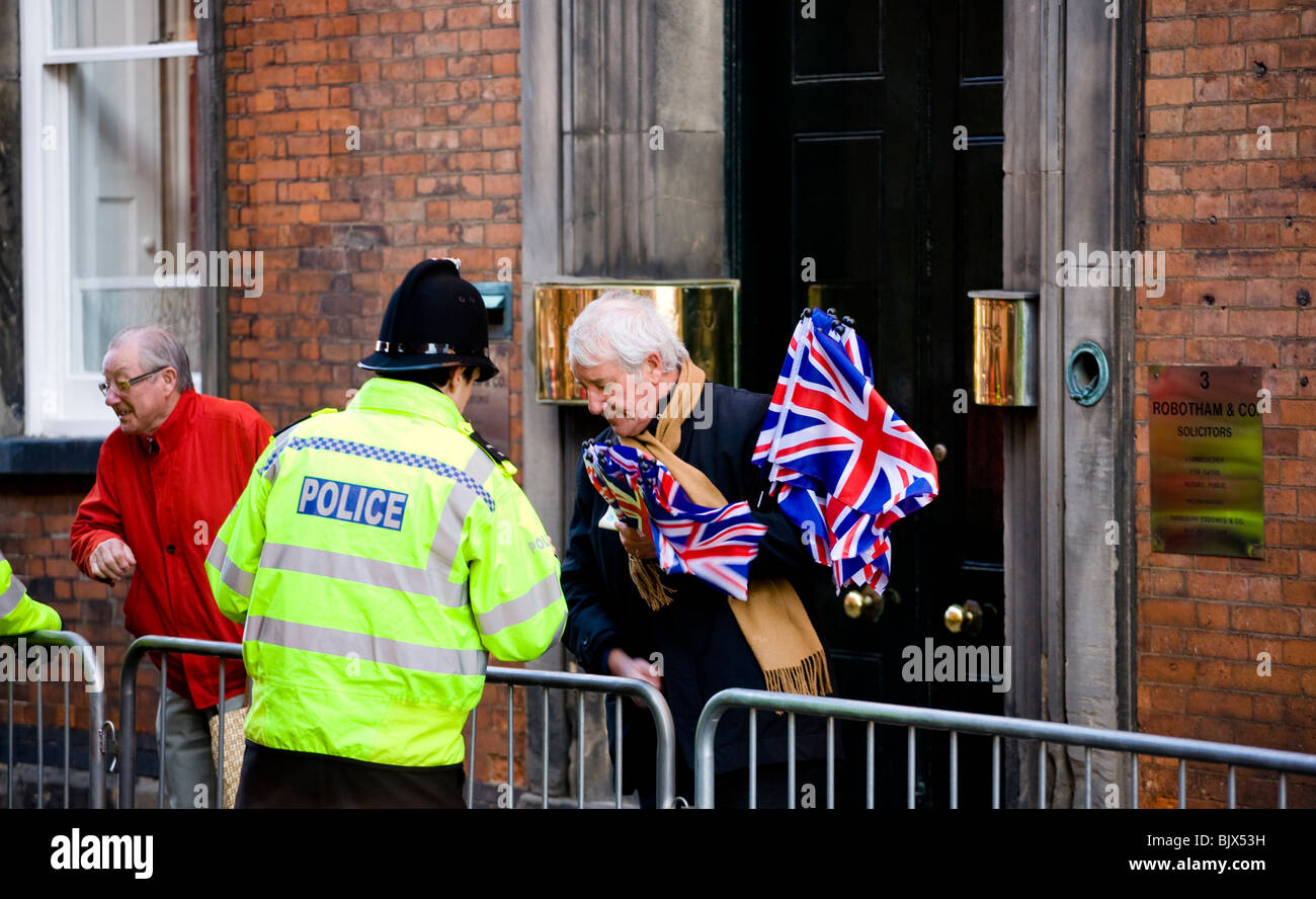 A UK policeman chats with a gentleman flag seller at an event in Derby where the Queen is to attend. Stock Photo