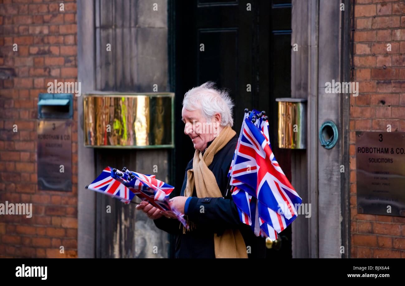 A man sells Union Jack flags outside Derby Cathedral during a state visit by the Queen for Maundy Thursday at Easter Stock Photo