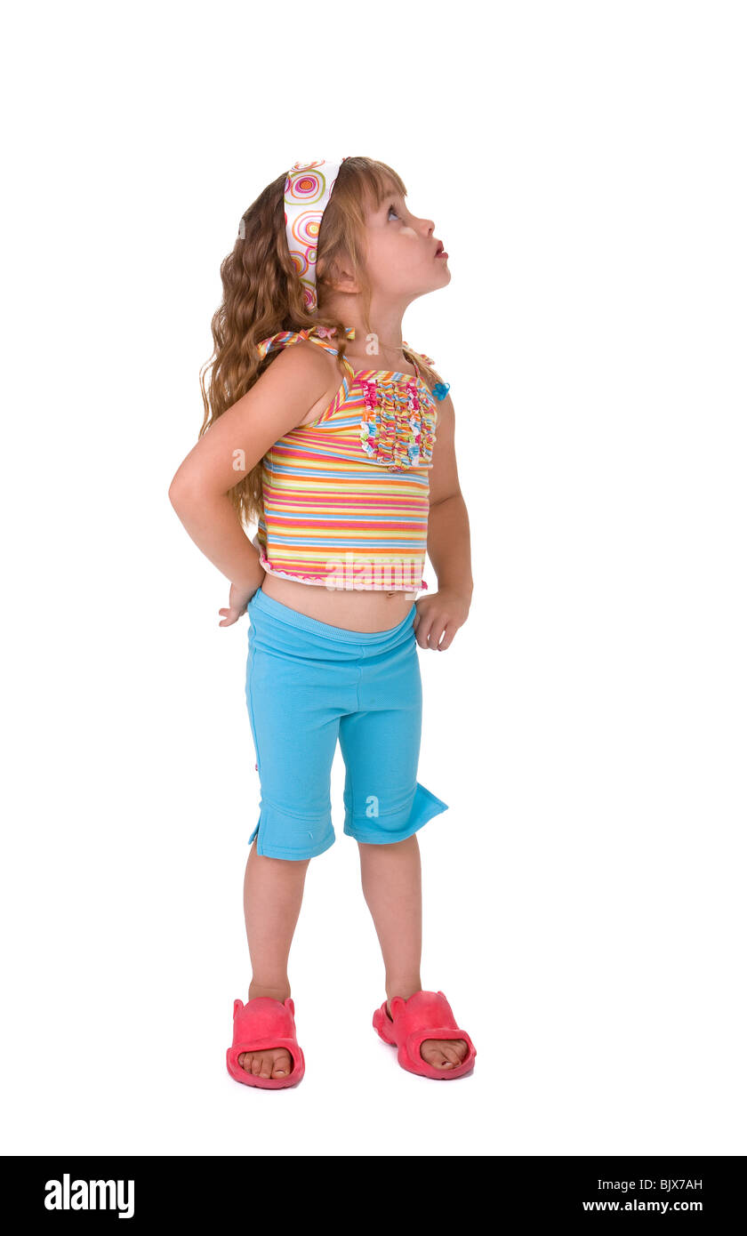 Full length view female child standing, looking upward,sideways. White background. Stock Photo