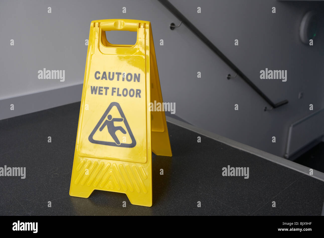 caution wet floor sign at the top of a set of stairs in a modern building Stock Photo